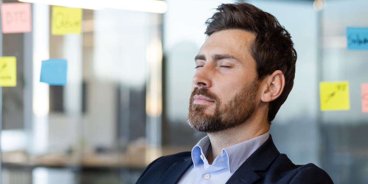 Man sitting at desk with closed eyes meditating