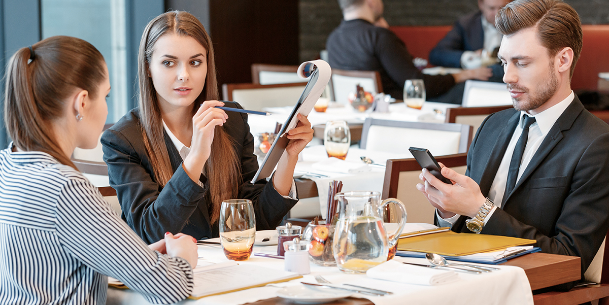 Business people in a restaurant discussing work over lunch.