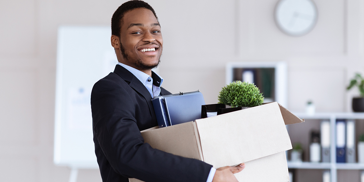 Smiling African American man with an office moving box